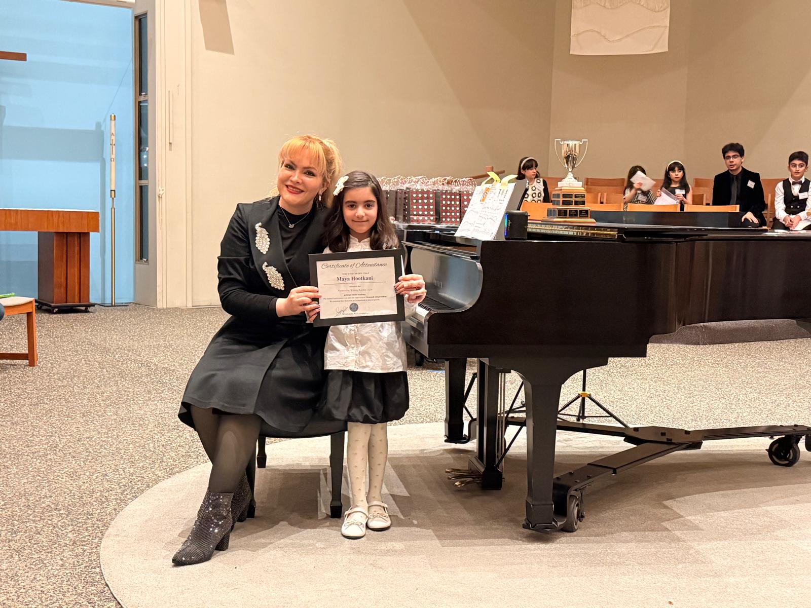 Student with certificate at grand piano